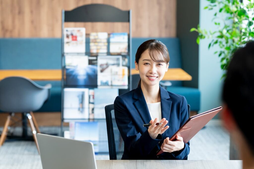 資料を持って相談者に説明する不動産会社の女性担当者