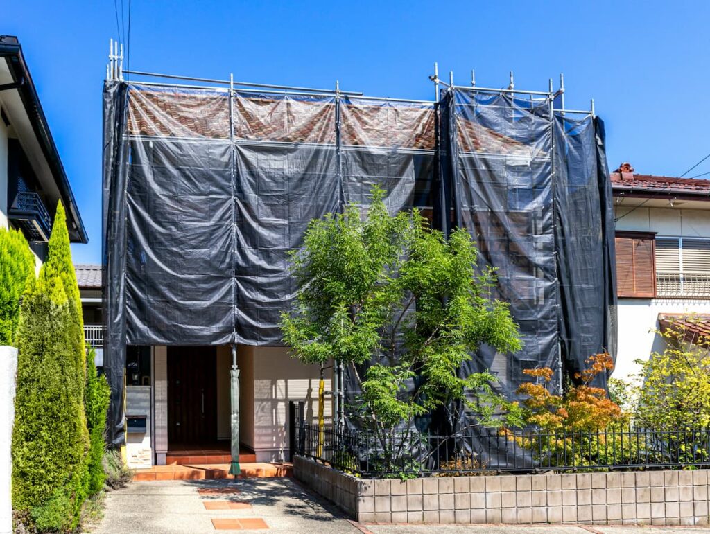 足場と養生シートで覆われた住宅の外壁リフォーム