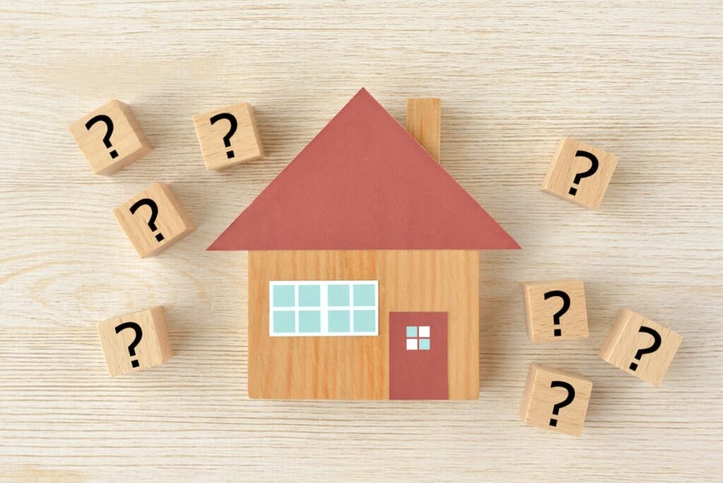 疑問符に囲まれた住宅模型