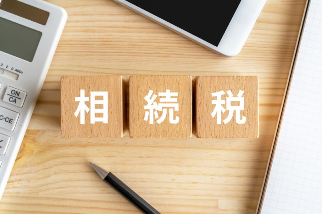 相続税と書かれた木製ブロックと電卓、タブレット