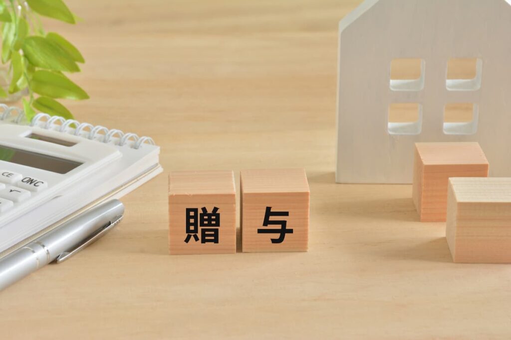 住宅の贈与と税金を表す木製ブロック