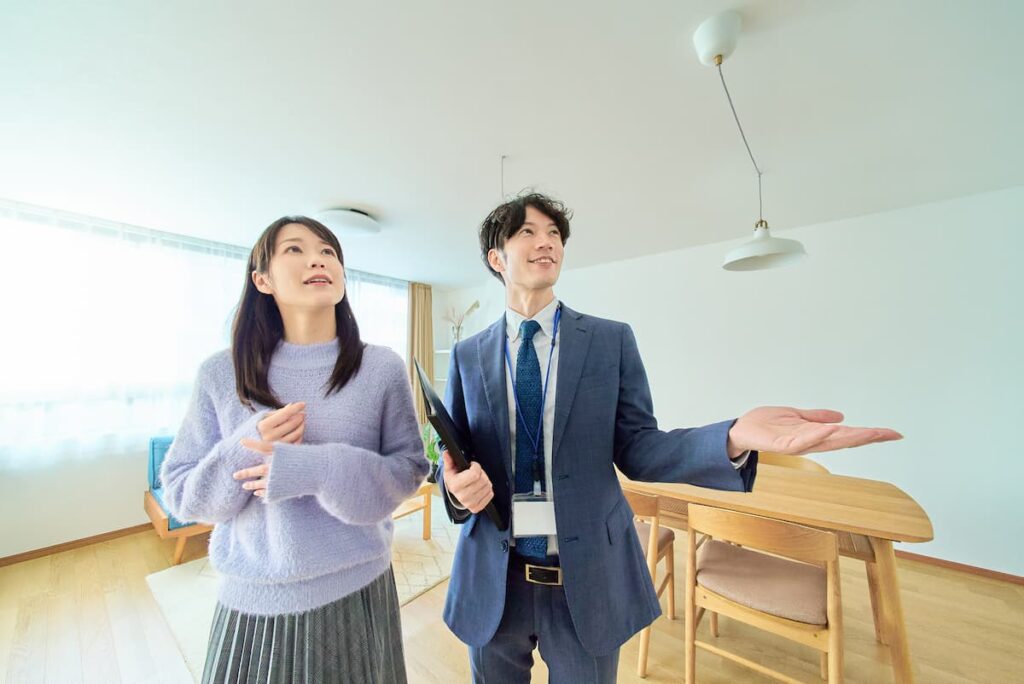 不動産担当者から室内の説明を受ける女性