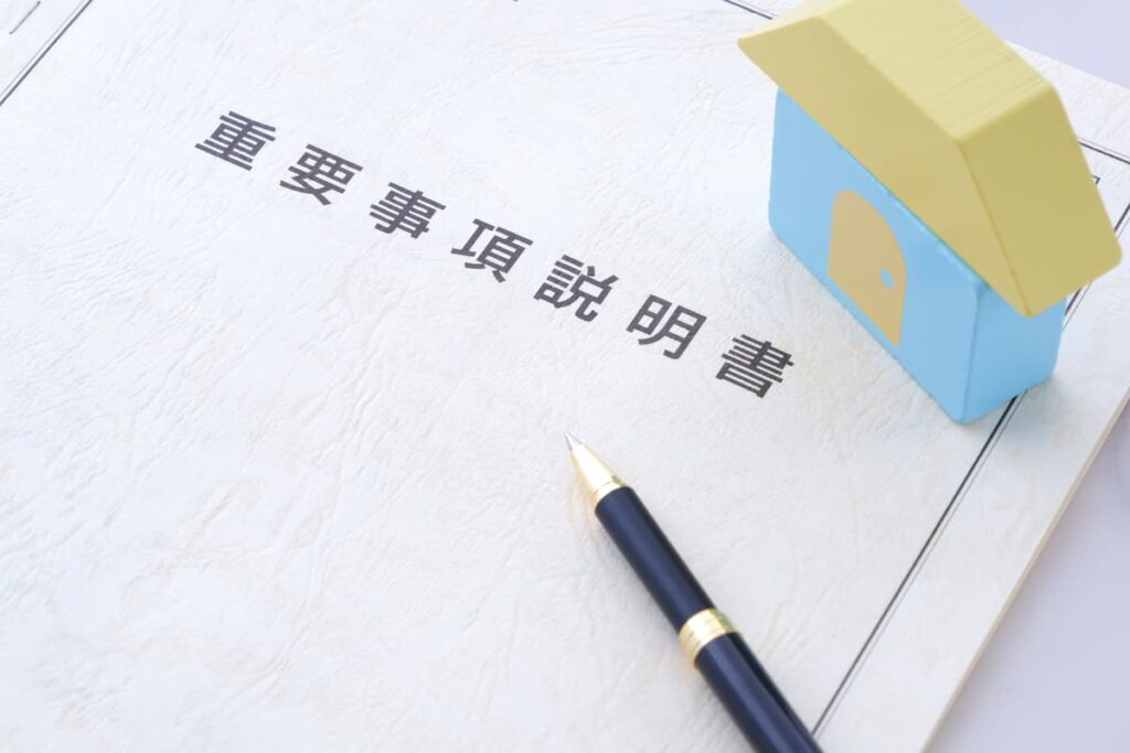 重要事項説明書と住宅模型、ボールペン