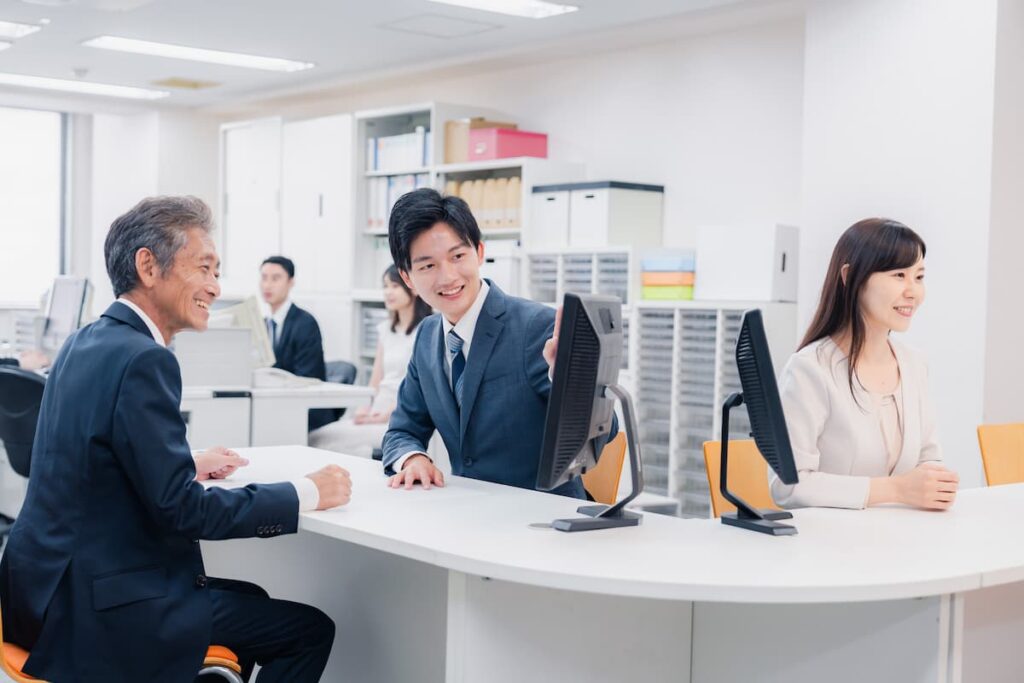 不動産会社の窓口で担当者に相談する男性