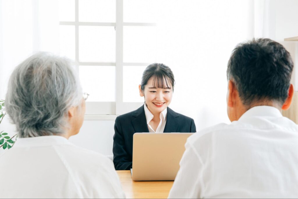 女性担当者に相談する高齢の夫婦