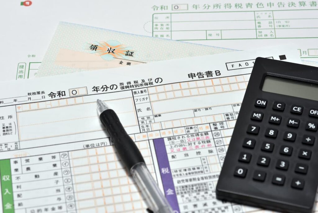 確定申告書と領収証、電卓、ボールペン