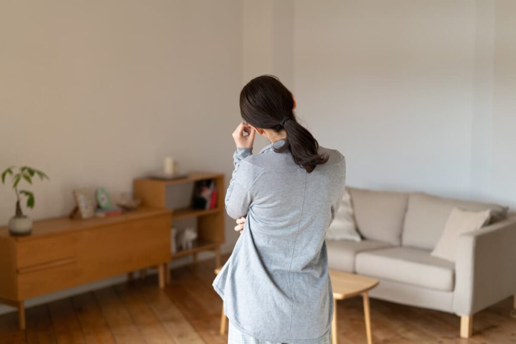 室内の状態を見て不安そうに考える女性
